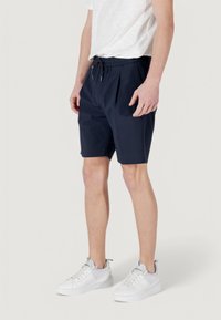 Pantaloni corti blu navy realizzati in tessuto leggero con elastico in vita e cordino. Il design include pinces frontali e una vestibilità morbida.