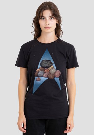 Schwarzes Baumwoll-T-Shirt mit einem Grafikdesign eines grauen Katers, der auf bunten dekorativen Steinen ruht, eingebettet in ein blaues sternförmiges Muster.