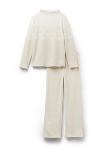 Lichtbeige lounge-set bestaande uit een longsleeve met sneeuwvlokpatroon en bijpassende broek. Zachte, gestructureerde stof met een comfortabele, losse pasvorm.