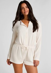 Roomkleurige geribbelde romper met knopen, lange mouwen, getailleerde taille, trekkoorde detail en korte zoom. Zachte textuur, casual ontwerp.