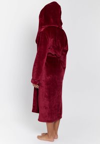 Burgundy huva morgonrock i mjukt, plyschigt tyg. Har långa ärmar, ett bälte i midjan och en knä-lång fåll. Slät, odekorerad yta.