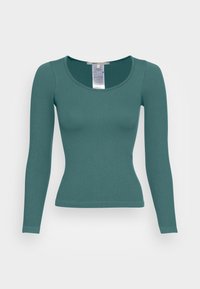 Rippenshirt mit langen Ärmeln in Teal. Verfügt über einen Rundhalsausschnitt und eine taillierte Silhouette. Das Material wirkt glatt mit subtiler Texturierung.