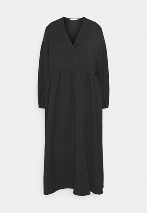 Robe midi noire à manches longues avec encolure en V, taille froncée et jupe ample, présentée sur un fond clair uni.