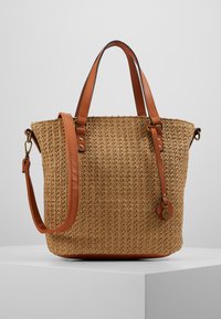 Geweven strooien tote bag met tan leren handvatten en accenten, voorzien van een textuur oppervlak en een afneembare crossbody riem.