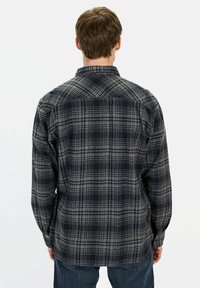 Sort og gråternet flannel skjorte med knap-ånds krave, lange ærmer og lige kant. Har et plæd mønster og manchetter med enkelt knap.