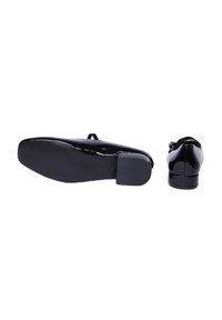 Scarpe in vernice nera con punta arrotondata, suola piatta e tacco basso. La scarpa presenta una fascia sulla tomaia.