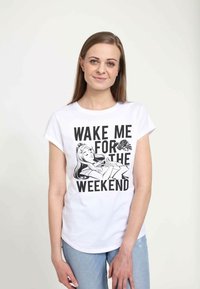 Hvid bomulds-tshirt med et grafisk print af en sovende figur omgivet af teksten: “VÆK MIG TIL WEEKENDEN.” Korte ærmer, afslappet pasform.