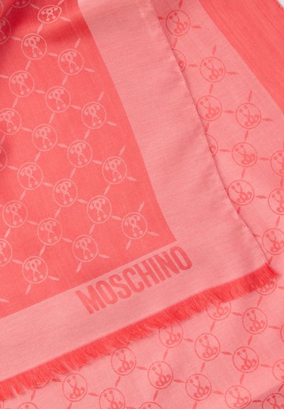 Šal koralne rožnate barve z vzorcem ponavljajočega se logotipa in resicami na robovih. Iz mehkega materiala, z odtisnjenim izrazitim imenom oblikovalske znamke.