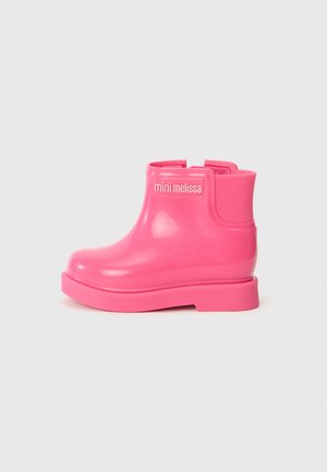 Pink rubber ankle boot with a glossy finish, rounded toe, and elastic side panels. Features a textured outsole for traction. Brand name visible.
