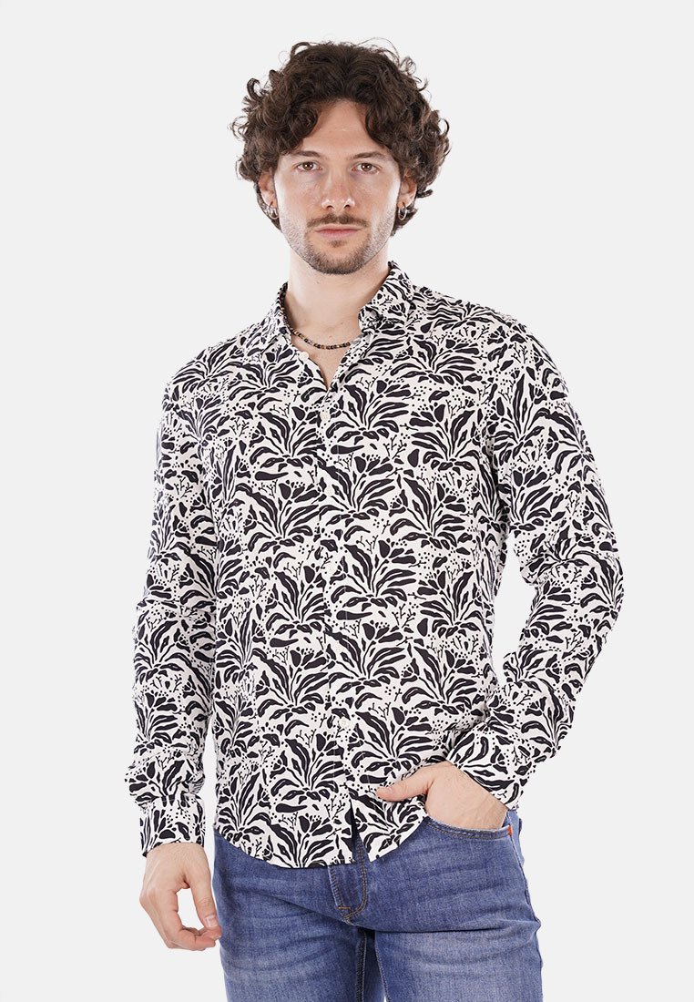 Camicia a maniche lunghe con motivo floreale in bianco e nero, realizzata in tessuto leggero, dotata di colletto e chiusura con bottoni, indossata con jeans di denim.