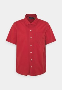 Chemise à manches courtes, rouge, à boutons, fabriquée en coton avec un col pointu et une poche poitrine. Comprend des boutons blancs et un ourlet droit.