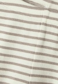 Pasiasty materiał w kremowych i jasnobrązowych odcieniach, o prążkowanej fakturze z widocznym przeszyciem na krawędziach.