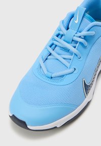 Hellblauer Sneaker aus Netzgewebe, mit Schnürsenkeln und einer Gummisohle. Verfügt über einen dunkelblauen Akzent und ein Logo an der Seite. Glatte Textur.