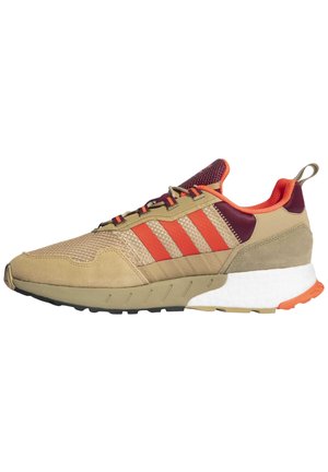 Beige en oranje sportschoen met rode strepen, bordeaux mesh tong, witte gedempte zool en oranje hielaccent, zijaanzicht.