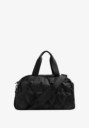 Sort quiltet duffel-taske med dobbelte håndtag og en justerbar skulderrem mod en hvid baggrund.