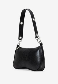 Bolso de mano de cuero negro con un acabado texturizado, forma curvada y una correa corta con herrajes metálicos y acentos circulares. Cierre con cremallera.