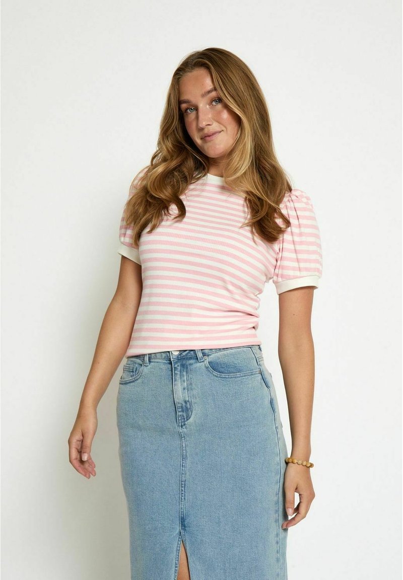 Gaiši rozā un baltā svītrainā ribota T-kreklu ar īsām pūkām, apvienots ar augsta vidukļa zilu džinsu svārku ar priekšējo šķēlumu.