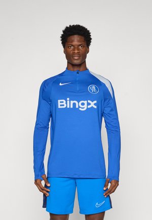 Blue long-sleeve athletic shirt with quarter zip, featuring white logo and text, paired with blue shorts. Smooth, lightweight material.