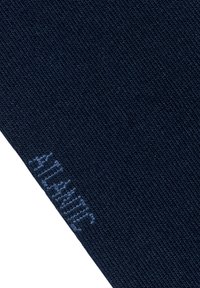 Granatowa tkanina o teksturowanym, żebrowanym wzorze; posiada jasnoniebieskie haftowane litery. Uwaga skupiona jest na materiałach i detalach wzornictwa.