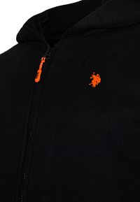 Black zip-up hoodie with orange USPA logo on chest and matching orange zipper pull tab.