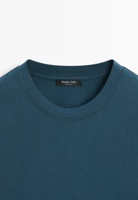 T-shirt in cotone color turchese con scollo rotondo. Presenta un'etichetta cucita all'interno con la scritta "Massimo Dutti". Tessuto morbido, texture liscia.