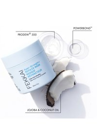 Fekkai Super Strength+ Reparerende Maske i en lyseblå krukke med et hvitt lokk, med tekstetiketter. Inkluderer biter av kokosskall.