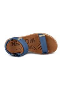 Blue fabric sandal with adjustable straps, tan suede footbed, and light brown rubber sole featuring a textured grip design.