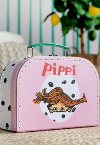 Vaaleanpunainen keinonahkainen matkalaukku, jossa on vihreä kahva, hahmokuvitus ja mustia pilkkuja. Pyöreä muoto, koristeellinen ommel.