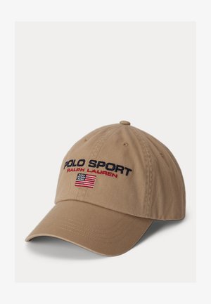 Bēšas krāsas beisbola cepure ar izšūtu "POLO SPORT" un Amerikas karogu. Tai ir izliekts vizieris un regulējams aizmugures siksniņa. Vienkāršs auduma tekstūrējums.