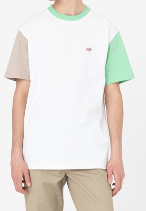 Camiseta de manga corta con cuerpo blanco, mangas en color caqui y verde menta, y un pequeño logo en el pecho. Fabricada en tejido de algodón.