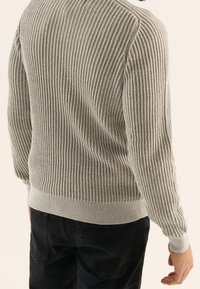 Szary prążkowany sweter wykonany z teksturowanej dzianiny, z okrągłym dekoltem i dopasowanymi mankietami, pokazany od tyłu na neutralnym tle.