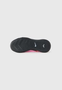Black rubber shoe sole features a textured pattern with grooves, and a pink upper edge with a small logo in white and neon accents.