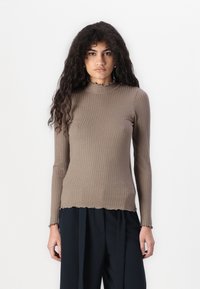 Ribbed brown long-sleeve top with a mock neck and uneven scalloped hem. Soft texture, fitted design, and elongated sleeves.