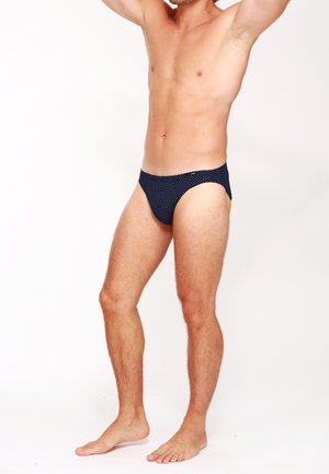 Marineblaue Badebrieft mit weißen Punkten, niedriger Schnitt, glatte Textur und minimale Bedeckung, ausgestattet mit einem weichen elastischen Bund.