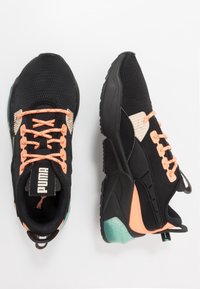 Scarpe da atletica nere Puma con lacci e dettagli pesca, tomaia in rete e accenti turchesi sulla suola, mostrate da viste superiore e laterale.