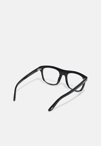 Óculos retangulares de plástico preto com acabamento brilhante. Apresentam detalhes em metal fino nas hastes e braços curvados e robustos. Lentes transparentes.