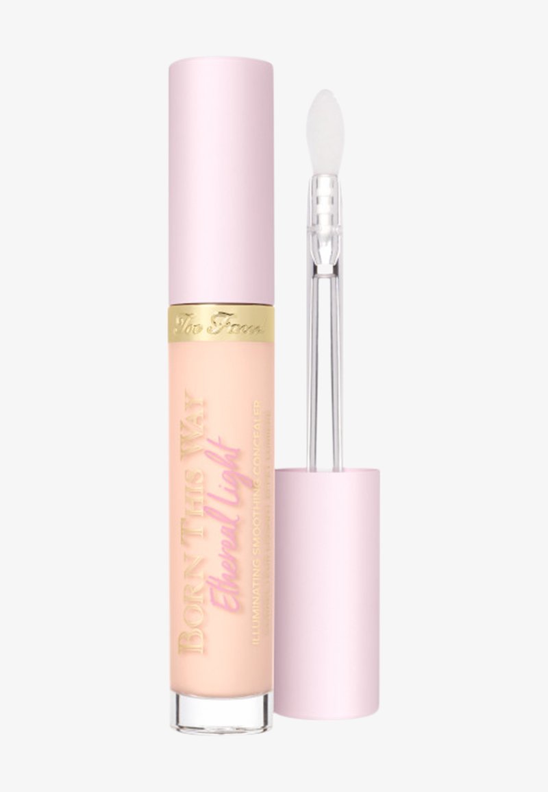Concealer tube with pink cap and gold band, labeled "Born This Way Ethereal Light," with attached doe-foot applicator shown beside it.
