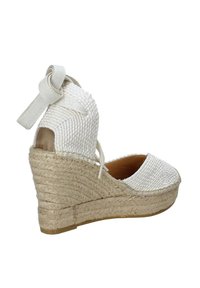 Espadrille a zeppa bianca intrecciata con piattaforma in juta, lacci alla caviglia e punta chiusa, con tomaia in tessuto testurizzato e interno liscio.