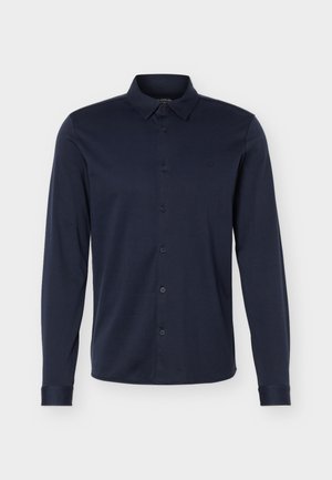Dark navy blue long-sleeve button-up shirt with collar and subtle embroidered logo on the left chest against a light background.