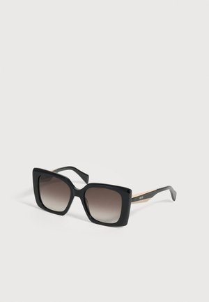Lunettes de soleil carrées oversize noires avec des verres dégradés foncés et des branches accentuées d’or, marquées « Liu Jo » sur un côté.
