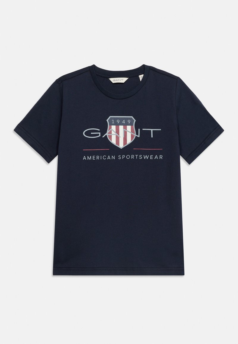 Μπλε ναυτικό κοντομάνικο t-shirt με το λογότυπο GANT, έμβλημα με ασπίδα και το 1949, καθώς και το κείμενο «American Sportswear» στο κέντρο του μπροστινού μέρους.