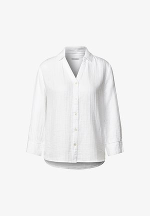 Camicia bianca a maniche lunghe con bottone frontale, colletto e un tessuto leggermente texture. Orlo e polsini arrotondati.