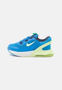 Chaussure de sport Nike en mesh bleu avec des accents noirs, semelle intermédiaire blanche, semelle extérieure verte et amortissement à air visible au niveau du talon.