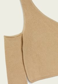 Beige ribbel gebreide top met een asymmetrisch ontwerp waarbij één schouder bloot is en een lange mouw aan de andere kant. Zachte textuur, aansluitende pasvorm.