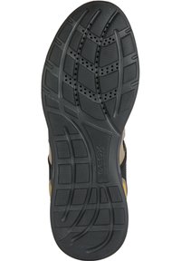 Suela de zapato de goma negra con un patrón de tracción texturizado, con orificios de ventilación y un logo en el costado, diseñada para la transpirabilidad y el agarre.