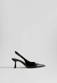Črne patent usnjene čevlje s slingbackom in ostro konico, ki imajo tanek peto in nastavljiv gleženjski trak. Gladka tekstura in eleganten dizajn.