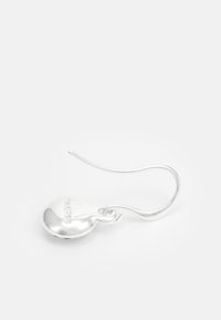 Srebrne viseče uške z gladko, zaobljeno obliko, ki imajo tanek kavelj za pritrditev in majhen graviran detajl na površini.