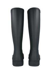 Pár vysokých černých gumových holínek z pohledu zezadu, ploché podrážky s vyraženým názvem značky na patách, hladký povrch s vertikálními švy.