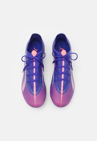 Scarpe da ginnastica viola con una parte superiore testurizzata, dettagli rosa e lacci coordinati. Presentano un design elegante e minimale con profilo basso.