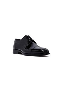 Chaussure habillée pour homme en cuir verni noir avec lacets, talon bas et design à bout caps orientée vers la droite sur un fond blanc.